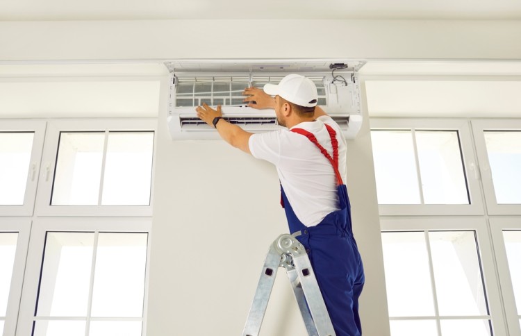 Technician installing split system air condition