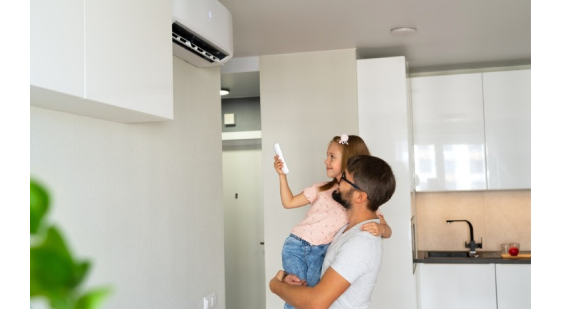 Girl with air conditioner remote turning on AC