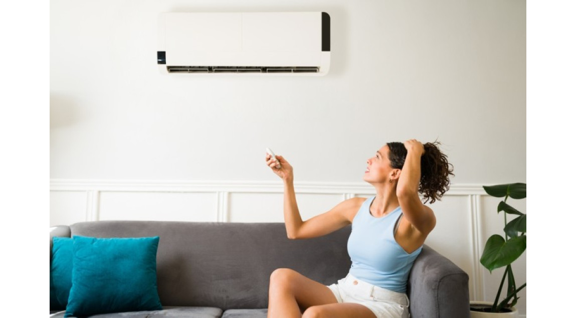 woman turning on split system AC